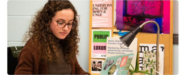 A students works on assignments at her studio desk.